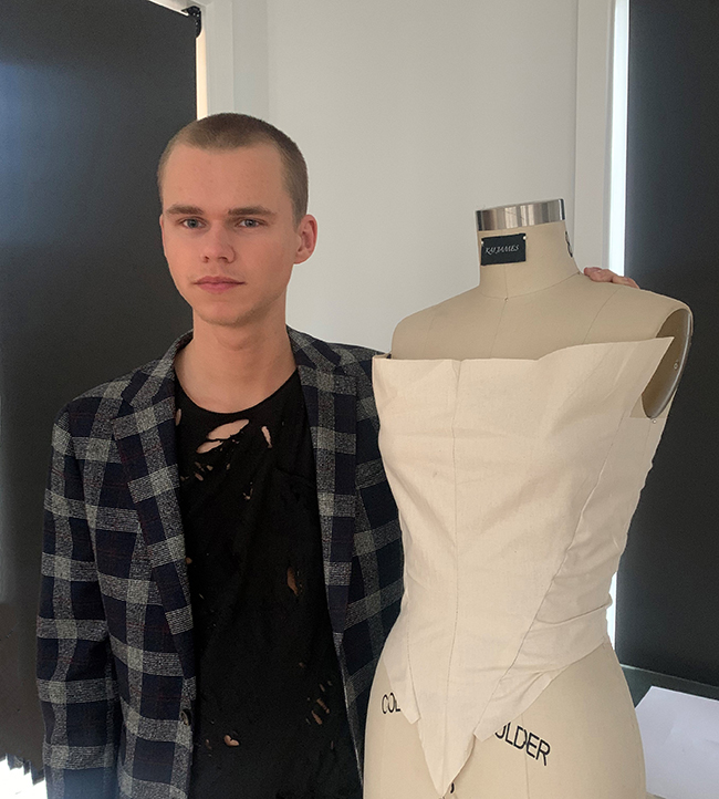 student standing next to large mannequin