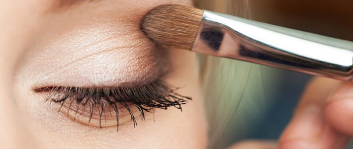 Close up of a person getting eye shadow painted onto their eyelids