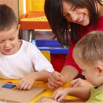 Laughing childcare teacher and children group 