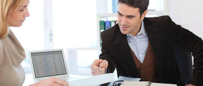 Male and female in office reading file