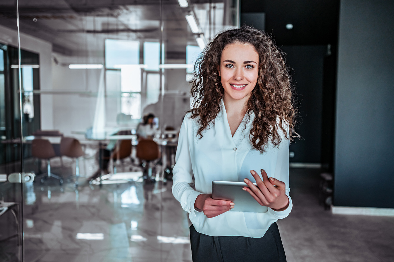 Female sitting in the office and wring on a notebook 