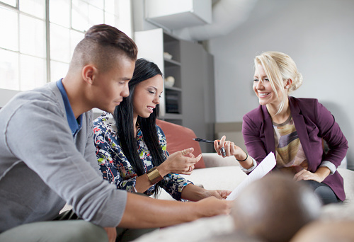 Couple talking to financial adviser in living room