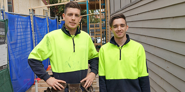2 male building apprentices in high vis