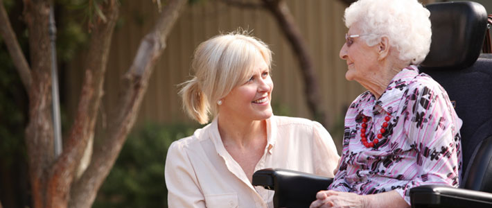 Elderly lady in wheelchair with female carer