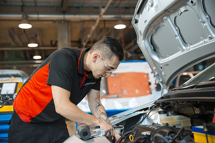 male student servicing car