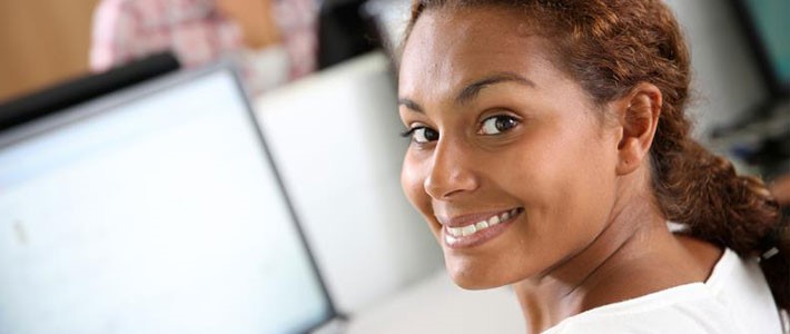 Young female smiling in front of computer