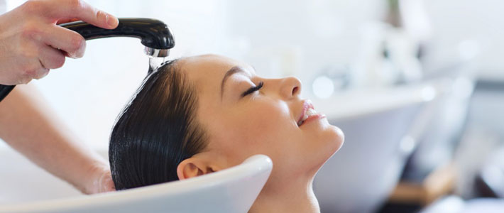 Hairdressing salon worker washing client's hair