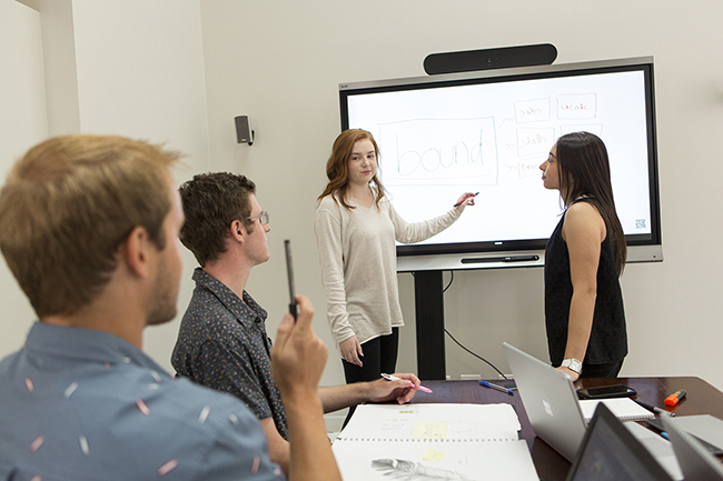 4 people in meeting room with whiteboard, brainstroming