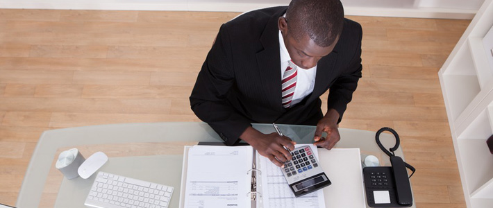 Male worker using a calculator to work out finances