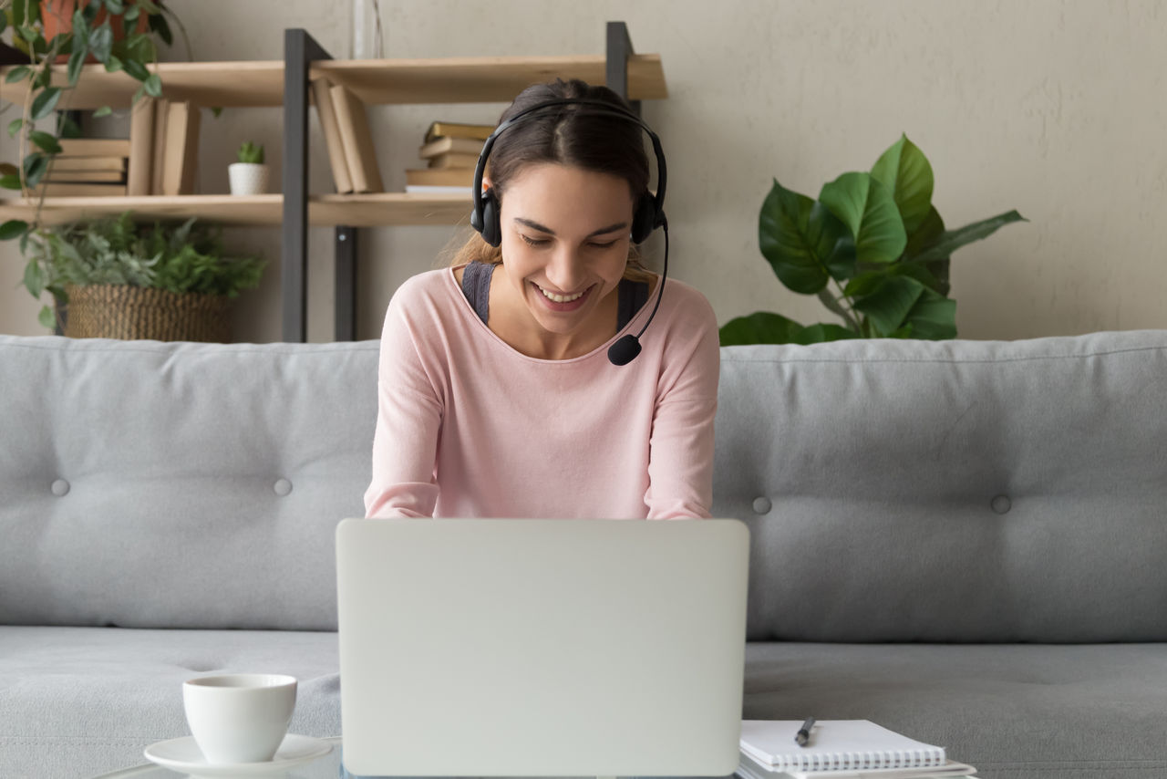 Young smiling lady on laptop with coffee