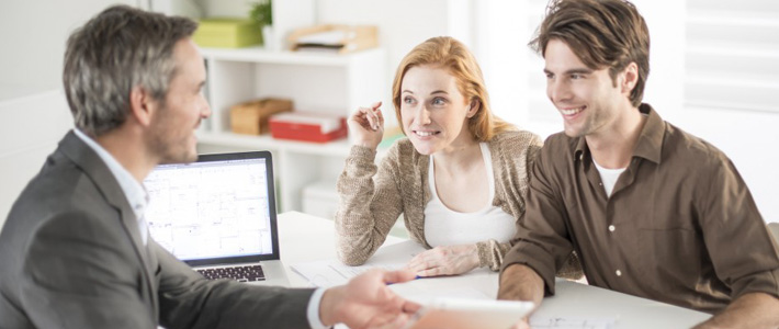 Couple in real estate office talking with real estate agent 