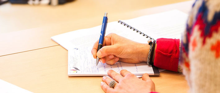 Image of a person writing in a notebook