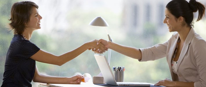 Two female smiling and shaking hand with each other 