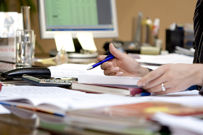 Documents on desk with hands holding papers