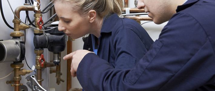 Female plumber working on fittings