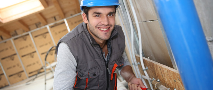 Plumber working on construction site