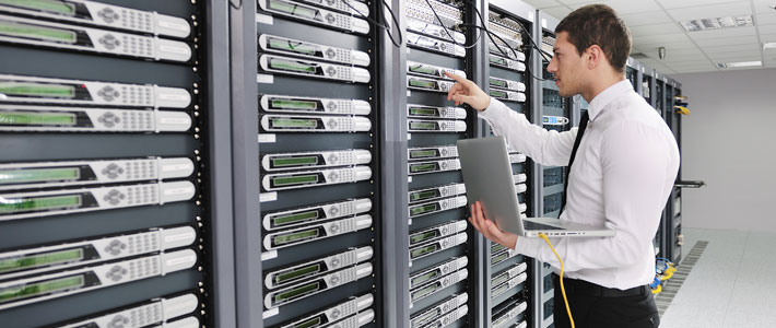 Young man holding a laptop and working with supercomputer 