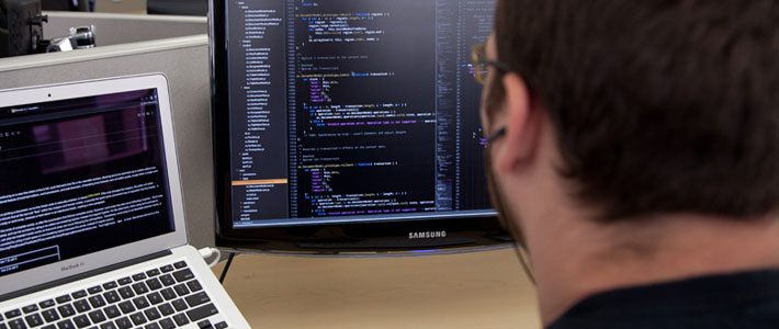 Young man looking at computer screens 